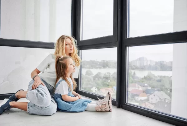 Danke dem Fenster-Online-Versand: Zwei Leute schauen aus dem Fenster in die Ferne.